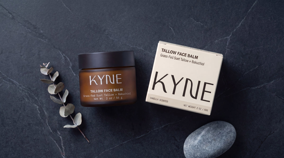 KYNE tallow face balm jar and packaging on a dark surface with a stone and plant.